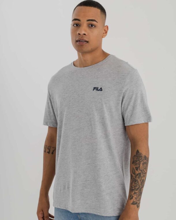 man wearing grey t-shirt with Fila logo on top left