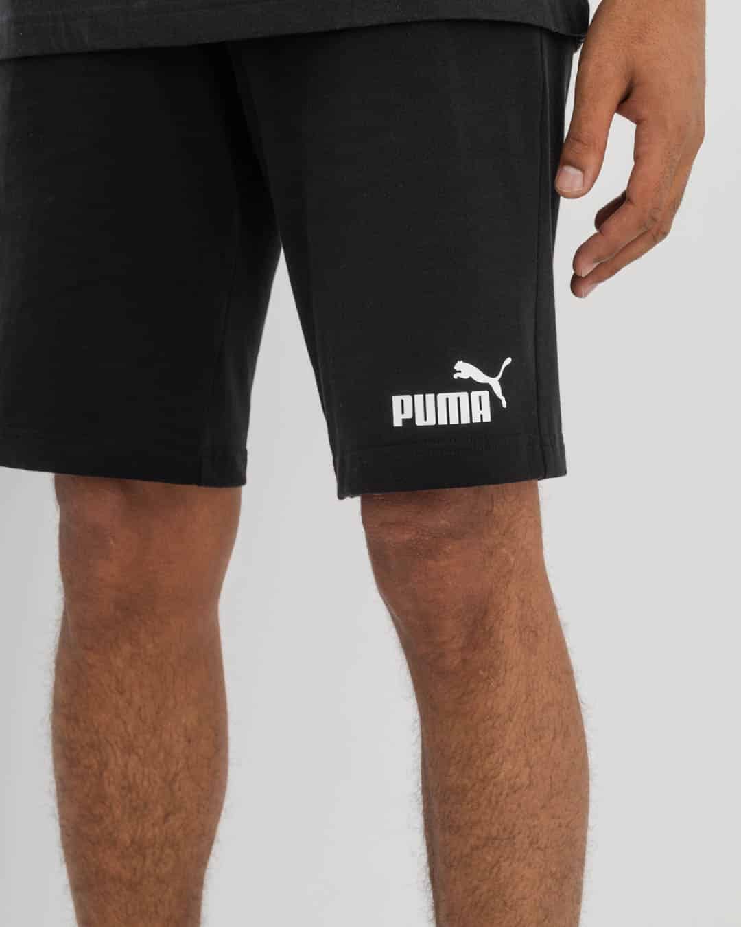 front view of man in black Puma t-shirt and black Puma shorts with Puma logo on bottom right.