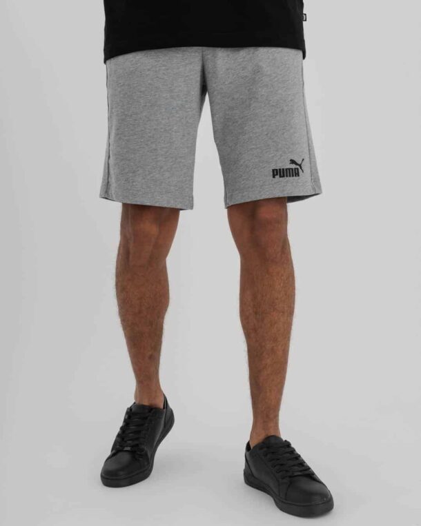waist down shot of man wearing Grey Puma shorts with Puma Logo on bottom right leg