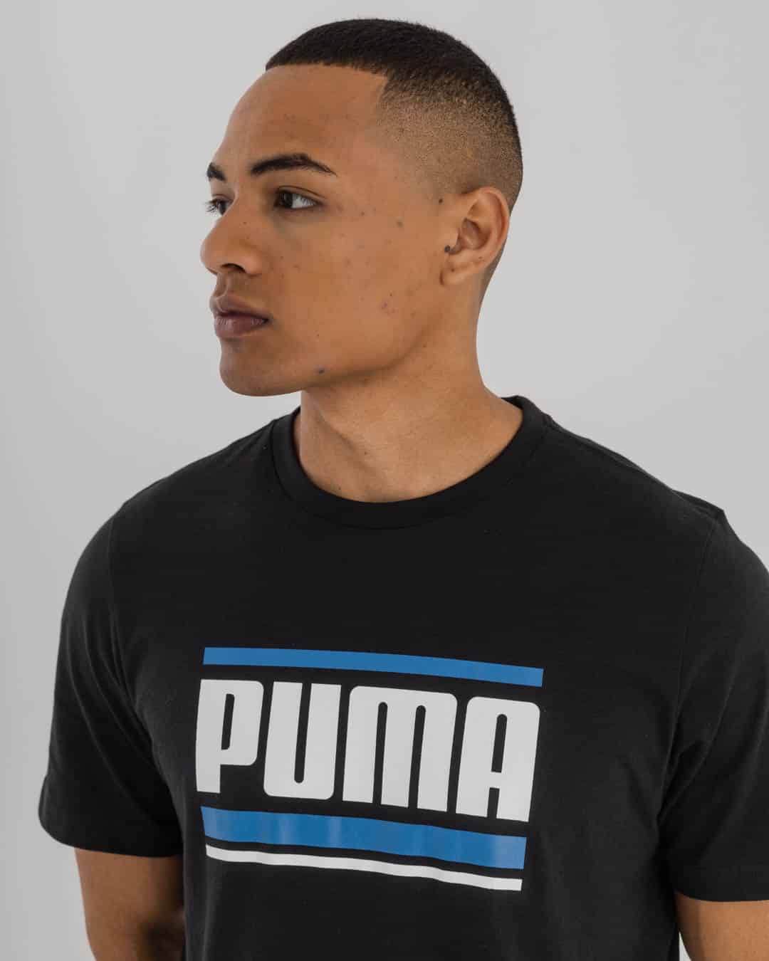 man in black Puma t-shirt with Puma Logo on chest