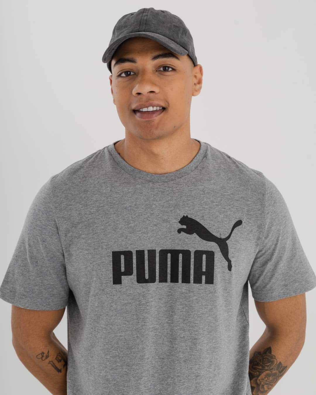 portrait shot of man wearing grey Puma t-shirt with logo on chest