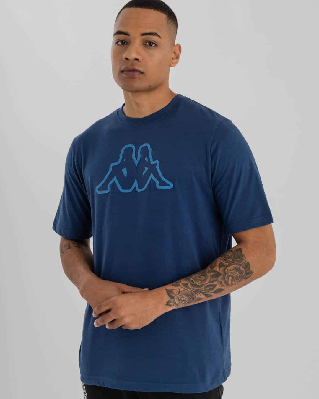 mid shot of man wearing navy Blue Kappa t-shirt with Kappa omini logo in blue on chest