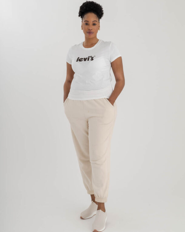 woman wearing white Levi's t-shirt with Levi's logo on chest in black and sand coloured track pants